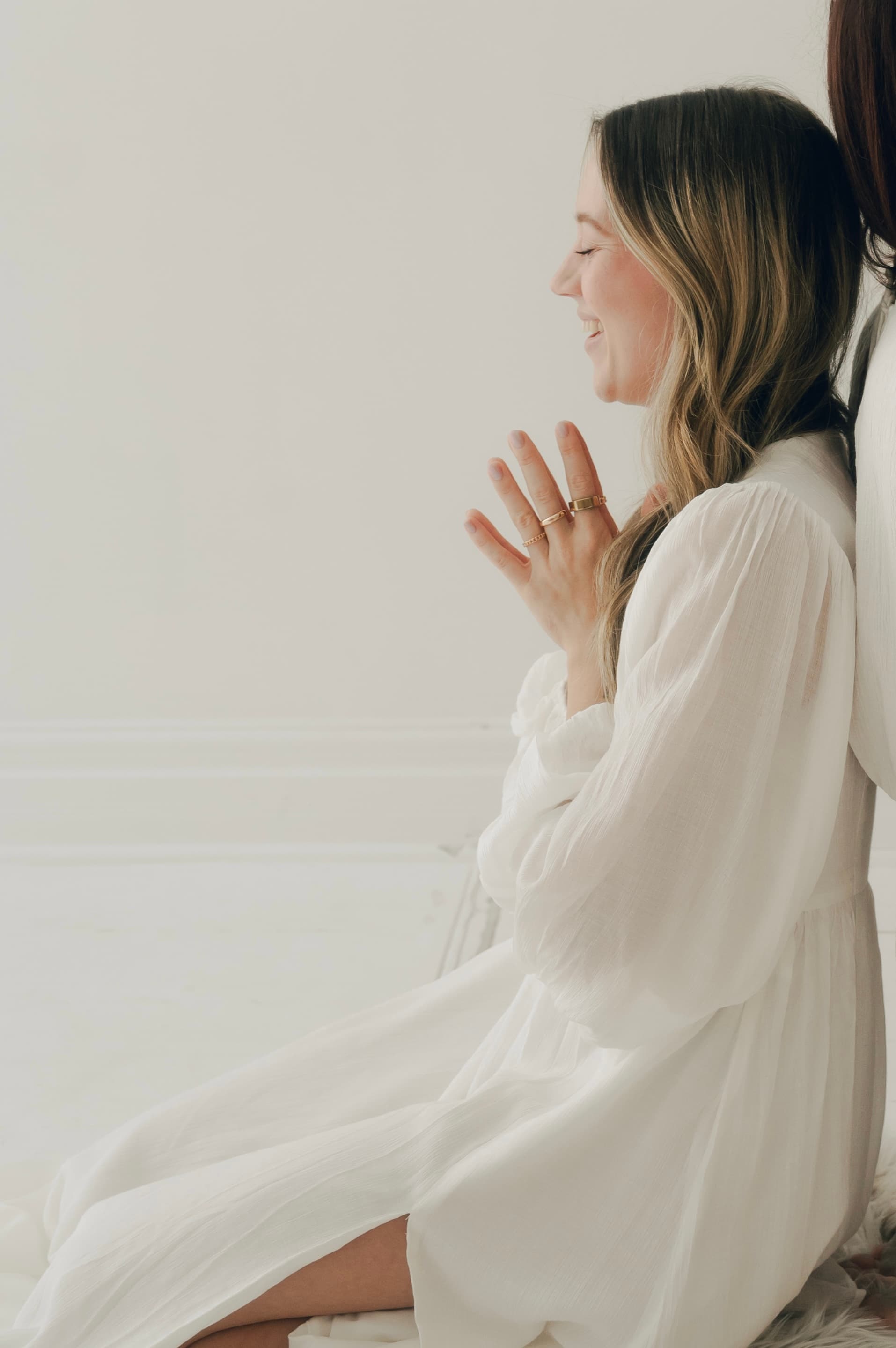 Lindsay in a white dress with hands in prayer